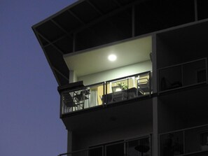 A multi-story building with a balcony on the upper level, featuring outdoor furniture. - Luxury Living in Cullen Bay (Darwin City)