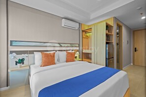 A modern hotel room with a large bed, a wardrobe, and a built-in air conditioning unit. - Eslin by Kozystay - Cilandak (South Jakarta)