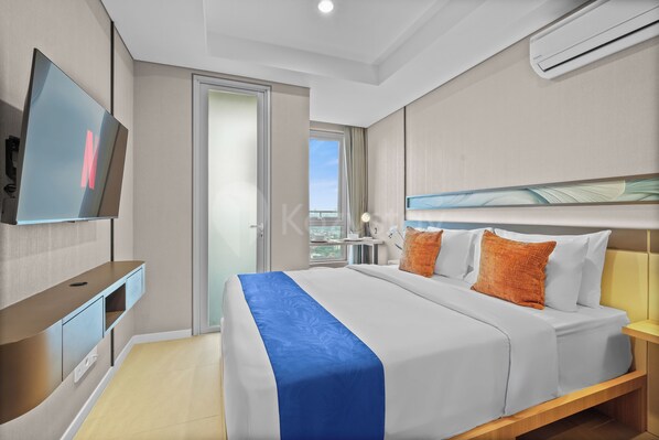 Una camera d'albergo con un letto, una TV, una scrivania e una finestra vista.