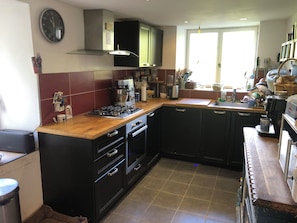 Eine Küche mit Gasherd, Backofen und Kaffeemaschine.
