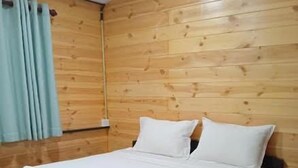 A single bed with white linens and pillows, a wooden headboard, and a red carpeted floor. - Hiriketiya Budget Stay (Dikwella)