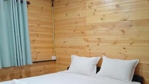 A single bed with white linens and pillows, a wooden headboard, and a red carpeted floor. - Hiriketiya Budget Stay (Dikwella)