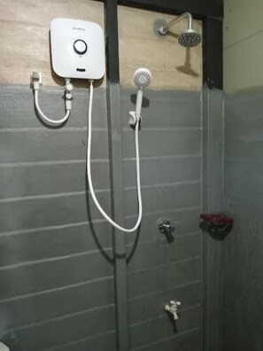 Une douche équipée d’un pommeau de douche à main et d’un panneau de commande fixé au mur.