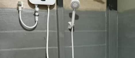 A shower with a handheld showerhead and a wall-mounted faucet.