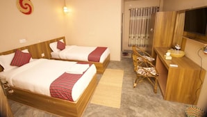 A hotel room with two beds, a desk, a television, and a shower area. - Narayani Vista Riverside Resort  (Kawasoti)