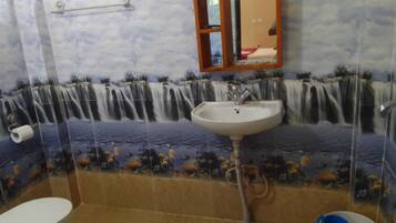 A bathroom with a sink, toilet, and a shower area.