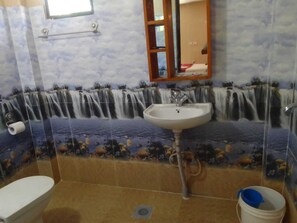 A bathroom with a sink, toilet, and a shower area.