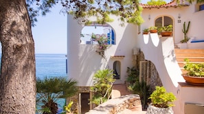 A coastal building with a stone staircase, potted plants, and a view of the sea. - Solemar Sicilia - Villa Emmax (Santa Flavia)