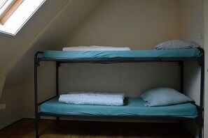 A bunk bed with a skylight above, a wooden floor, and a plain wall. - Holiday home with 2 bedrooms (Hollum Ameland)