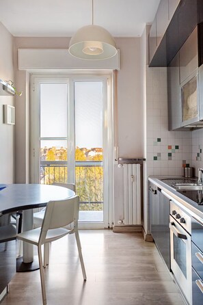 Een moderne keuken met een eethoek, een groot raam en uitzicht op de stad.