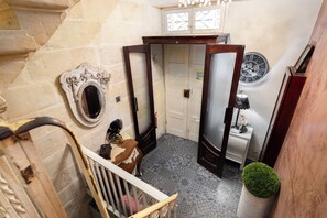 A narrow stairway with a wooden handrail, a white door with a frosted glass panel, and a wall-mounted clock. - Maltese Home w/ Balcony - Valletta (Valletta)