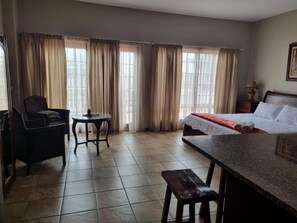 A hotel room with a bed, a small table, a chair, and a window with curtains. - Skilpadvlei Accommodation (Velddrif)