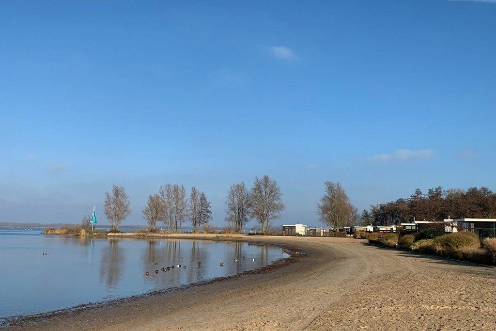 Una propiedad junto al lago con un sendero de tierra que conduce a una hilera de cabañas.
