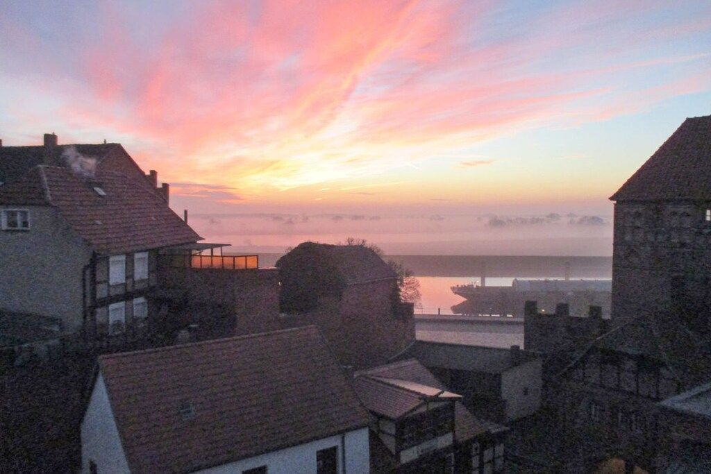 Blick auf eine Stadt mit Gebäuden und einem Fluss im Abendrot.