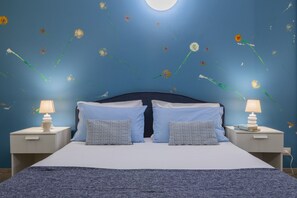 A bedroom with a bed, two nightstands, and a wall with floral decals. - Housing Giulia - Apartment 8 by Wonderful Italy (Turin)
