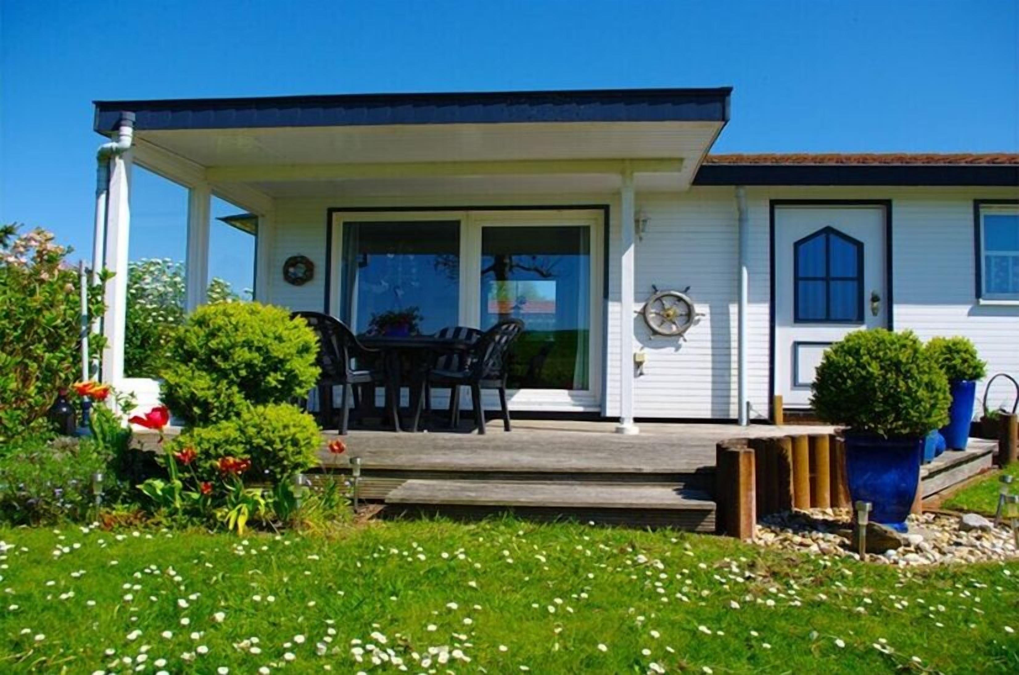 A single-story house with a covered porch, a door, and a window.