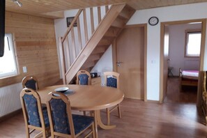 A wooden interior with a dining table and chairs, a staircase, and a clock on the wall. - Holiday home in Elsfleth with swimming pool (Elsfleth)