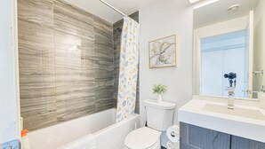 Une salle de bain moderne équipée d’une douche, de toilettes et d’un lavabo.