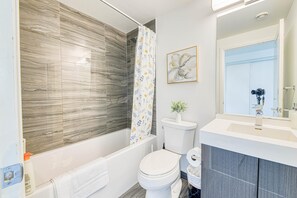 Une salle de bain moderne équipée d’une douche, de toilettes et d’un lavabo.