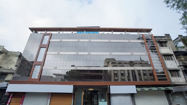 Un immeuble à plusieurs étages doté d’une façade moderne, de grandes fenêtres et d’une entrée bien visible.