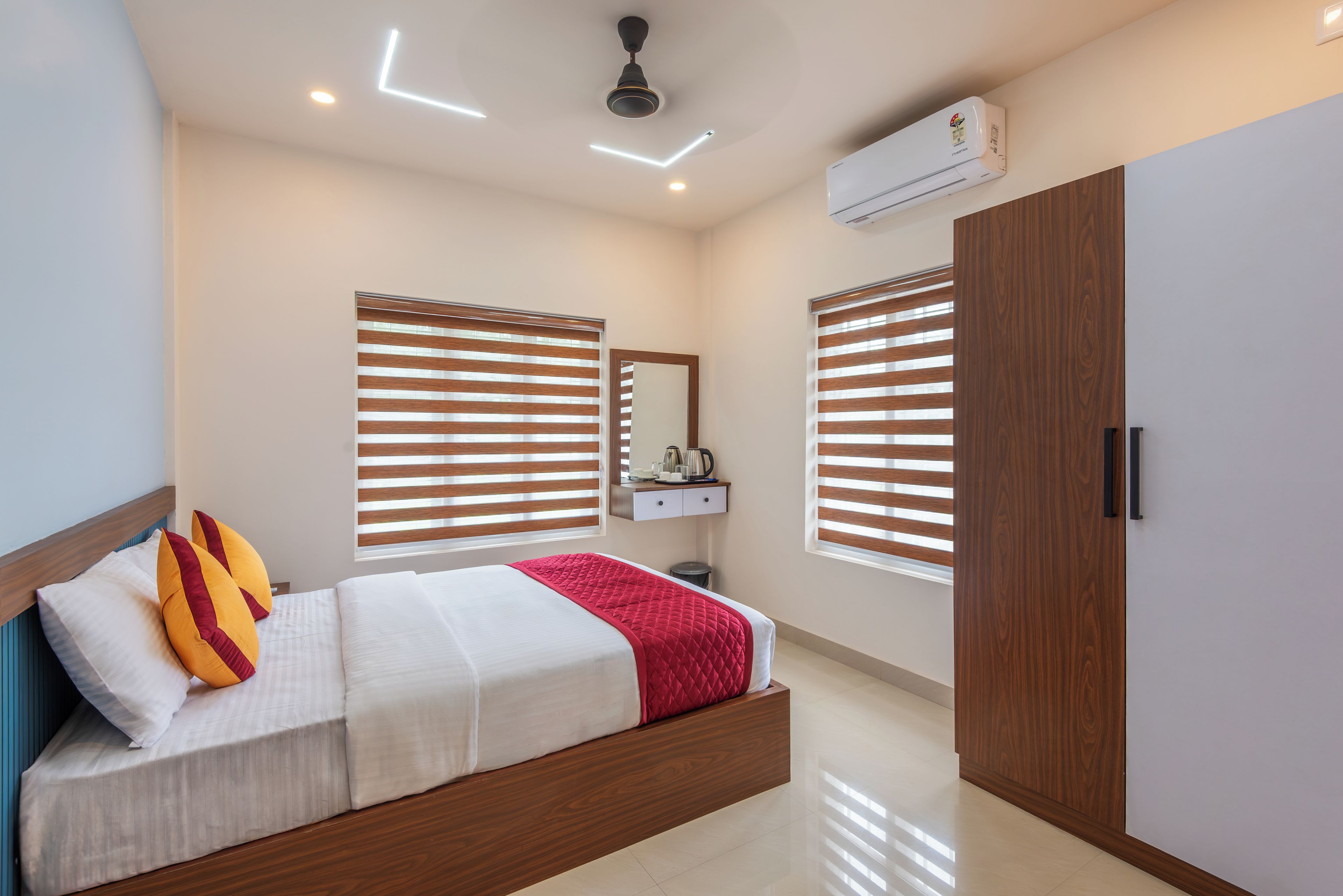 Un dormitorio moderno con cama, armario, espejo y equipo de aire acondicionado.