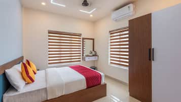 Un dormitorio moderno con cama, armario, espejo y equipo de aire acondicionado.