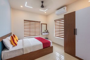 Un dormitorio moderno con cama, armario, espejo y equipo de aire acondicionado.