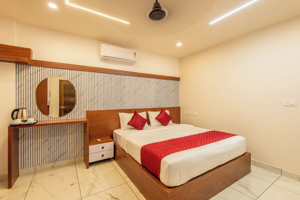 Quarto de hotel com cama, mesa de cabeceira e espelho.