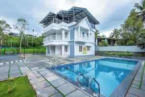 A modern two-story building with a swimming pool in front. - Cosvalia Pool Resort (Wayanad)