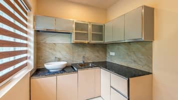 Una cocina compacta con un lavamanos tipo cuenco, un lavabo doble y un horno empotrado.