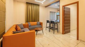 Una sala moderna con un sofá, una mesa de centro y un comedor con sillas.