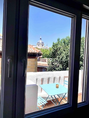 Una ventana con vistas a un edificio con cúpula y tejado de tejas.