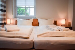 Ein Doppelbett mit weißer Bettwäsche und zwei Nachttische mit Lampen.