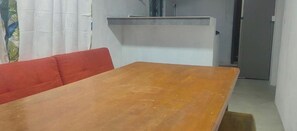 A room with a wooden table, a red sofa, and a white cabinet. - Henz and Sia Tourist Residence 2 — Your Peaceful Island Home in Rodrigues (Reposoir)
