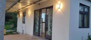 A building with a covered entrance, glass doors, and exterior lighting.