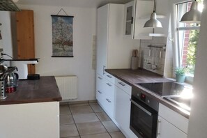 Eine Küche mit weißen Schränken, einem eingebauten Backofen und einem Fenster mit Blick.