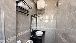 A compact bathroom with a toilet, a sink, and a towel rack. - NJIRO LUXURY RESORT (Arusha)