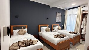 A hotel room with three wooden beds, a large window with curtains, and a wardrobe. - NJIRO LUXURY RESORT (Arusha)