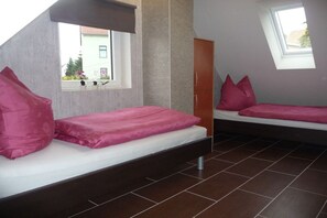 A room with two beds, a window, a wardrobe, and a view of the outside. - Holiday home with 2 bedrooms (Altendorf)