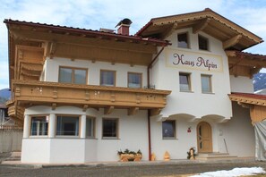 A two-story building with a sign reading 'Haus Alpina.' It features a balcony with wooden railings and a traditional Alpine architectural style. - Top 2 in the Alpin house (Uderns)