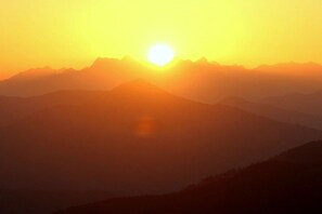 Una serralada amb el sol ponent-se o sorgint darrera.
