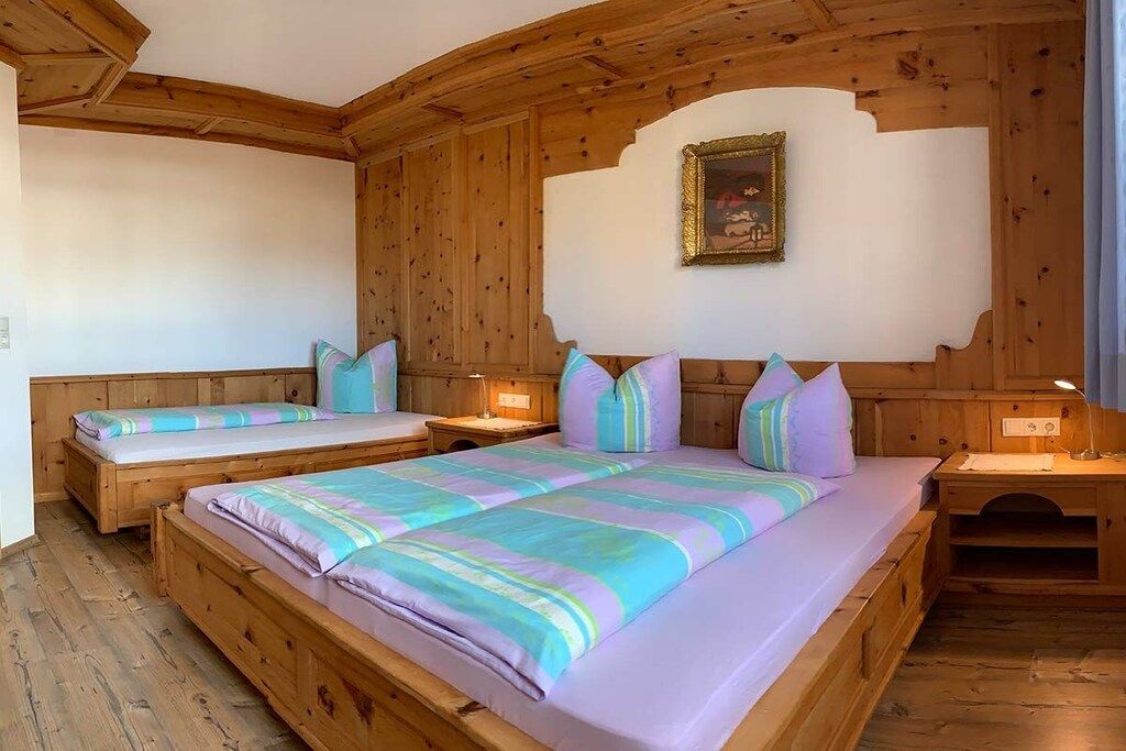 A wooden room with two beds, a nightstand, and a wall-mounted picture.