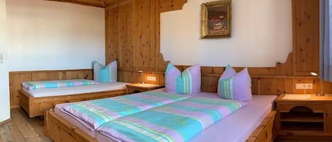 A wooden room with two beds, a nightstand, and a wall-mounted picture.
