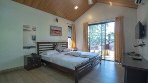 Quarto com cama de madeira, mesa de cabeceira, escrivaninha e uma janela grande com cortinas.