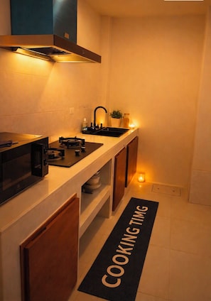 A modern kitchen with a microwave, stove, and sink.