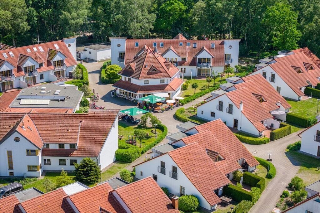 Um bairro residencial com várias casas, cada uma com telhado de telhas vermelhas e paredes brancas.