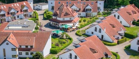 Um bairro residencial com várias casas, cada uma com telhado de telhas vermelhas e paredes brancas.
