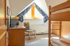 A room with a bunk bed, a desk with a computer, a chair, and a window with curtains. - 10/T6 holiday home park “Freesenbruch” (Zingst (Ostseeheilbad))