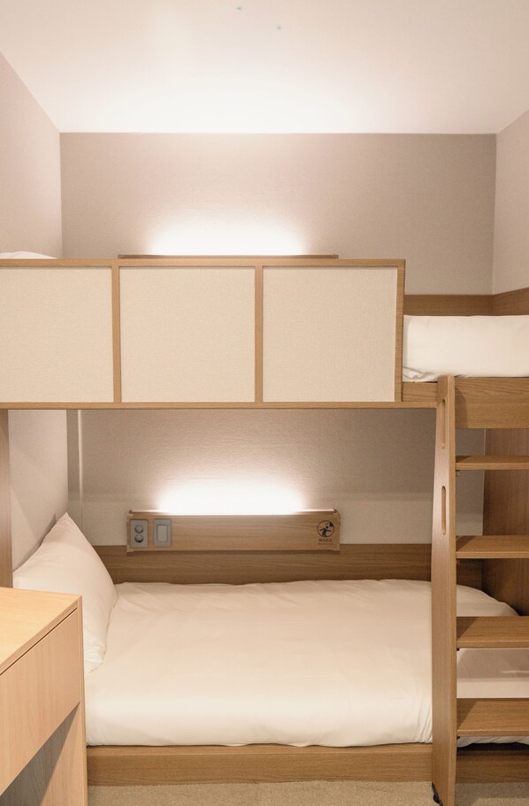 A bunk bed with a lower bunk and a top bunk, both with wooden frames and white bedding.