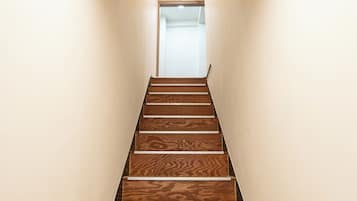 A wooden staircase with a handrail, leading to a door at the top.